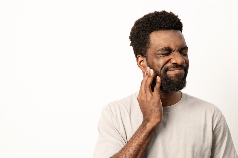 A patient in severe tooth pain being examined by an emergency dentist